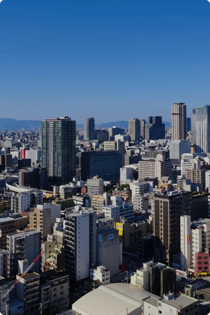青空に広がる都市の街並み。企業の持続的な成長と飛躍を支援するイメージ