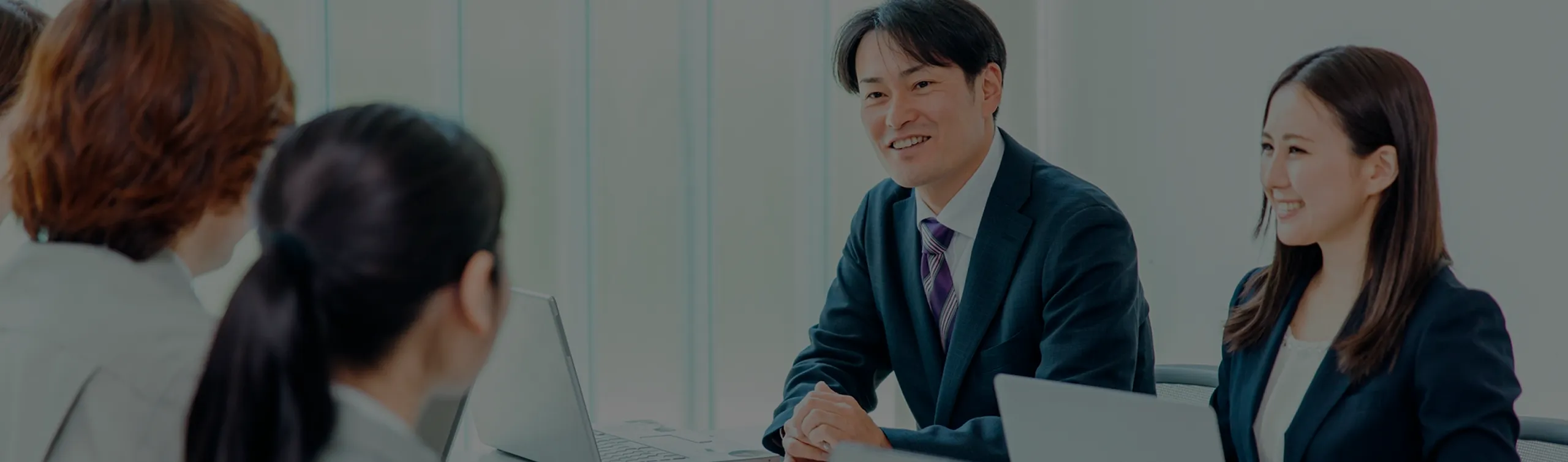 会議室でクライアントに提案を行うコンサルティング営業の様子