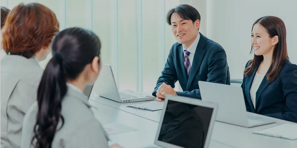 会議室でクライアントに提案を行うコンサルティング営業の様子