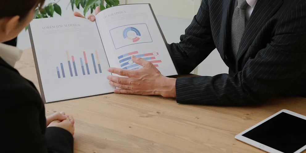 グラフや図解などのデータ資料を用いて丁寧に説明を行う様子