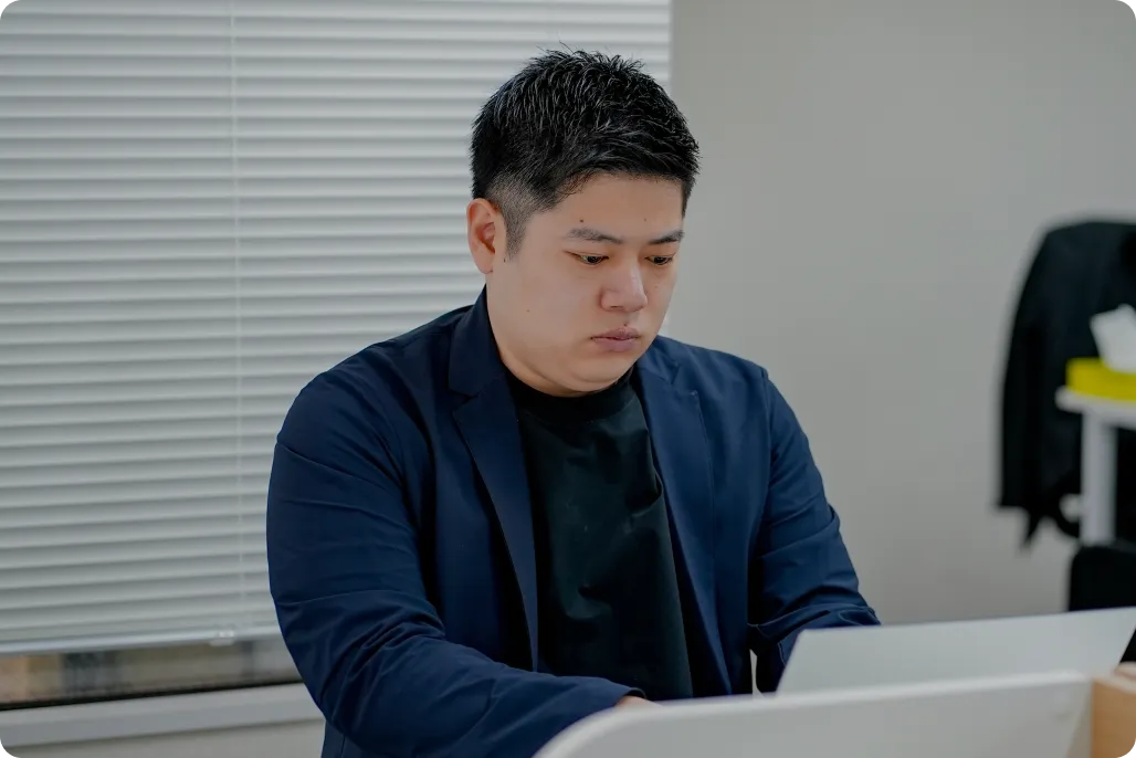 オフィスで真剣な表情でPCに向かい、データ分析や戦略立案に取り組む社員