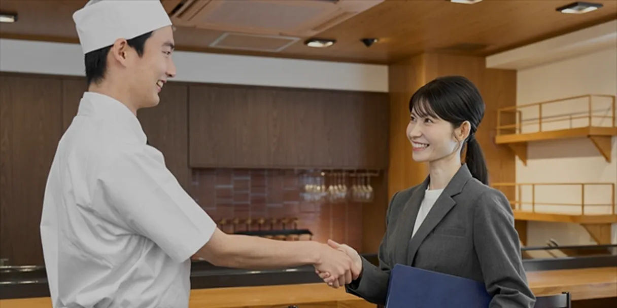 法人向けソリューションの契約が成立した際の、お店と営業マンの信頼の握手