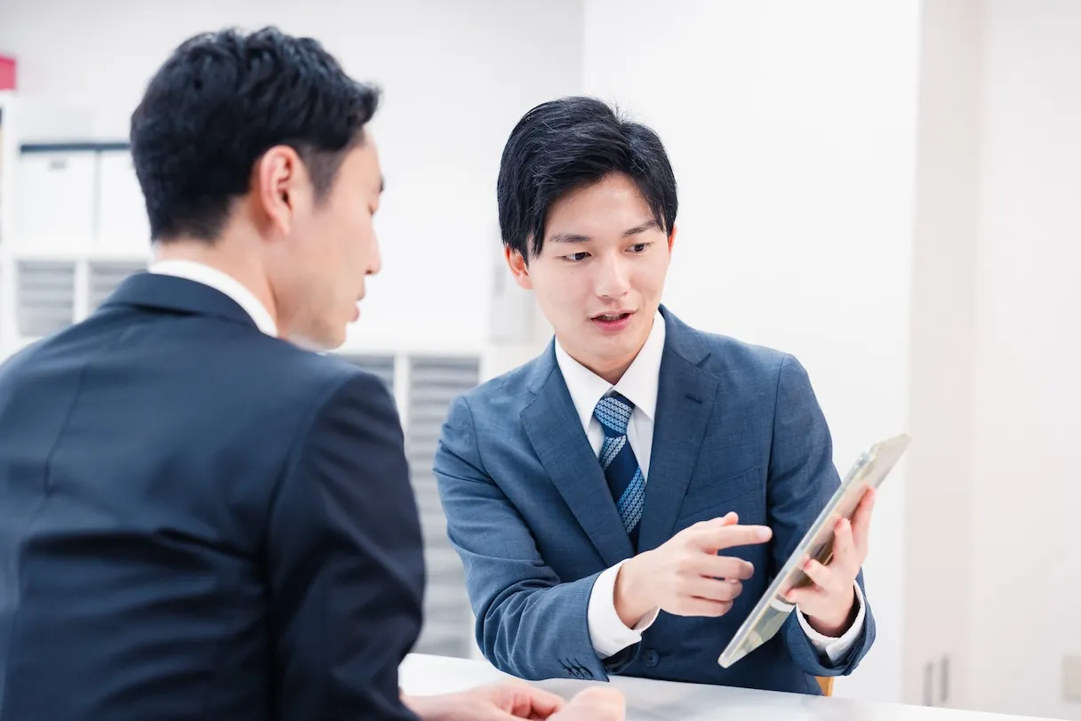 タブレットを使ってサービス内容を説明する営業担当者